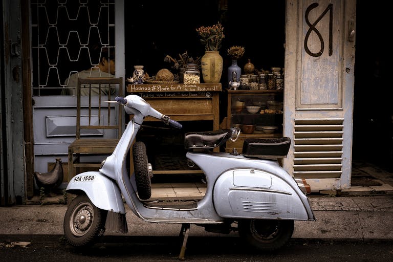 White and Black Motor Scooter Parked Near Building