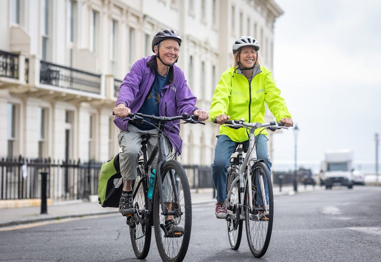 Smiling Women on Bikes on Street