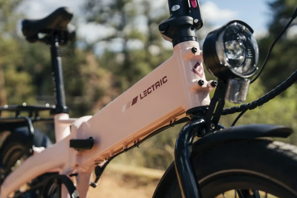 Close-up of pink Lectric XP Lite 3 folding e-bike frame, integrated front headlight, and front fender
Copy